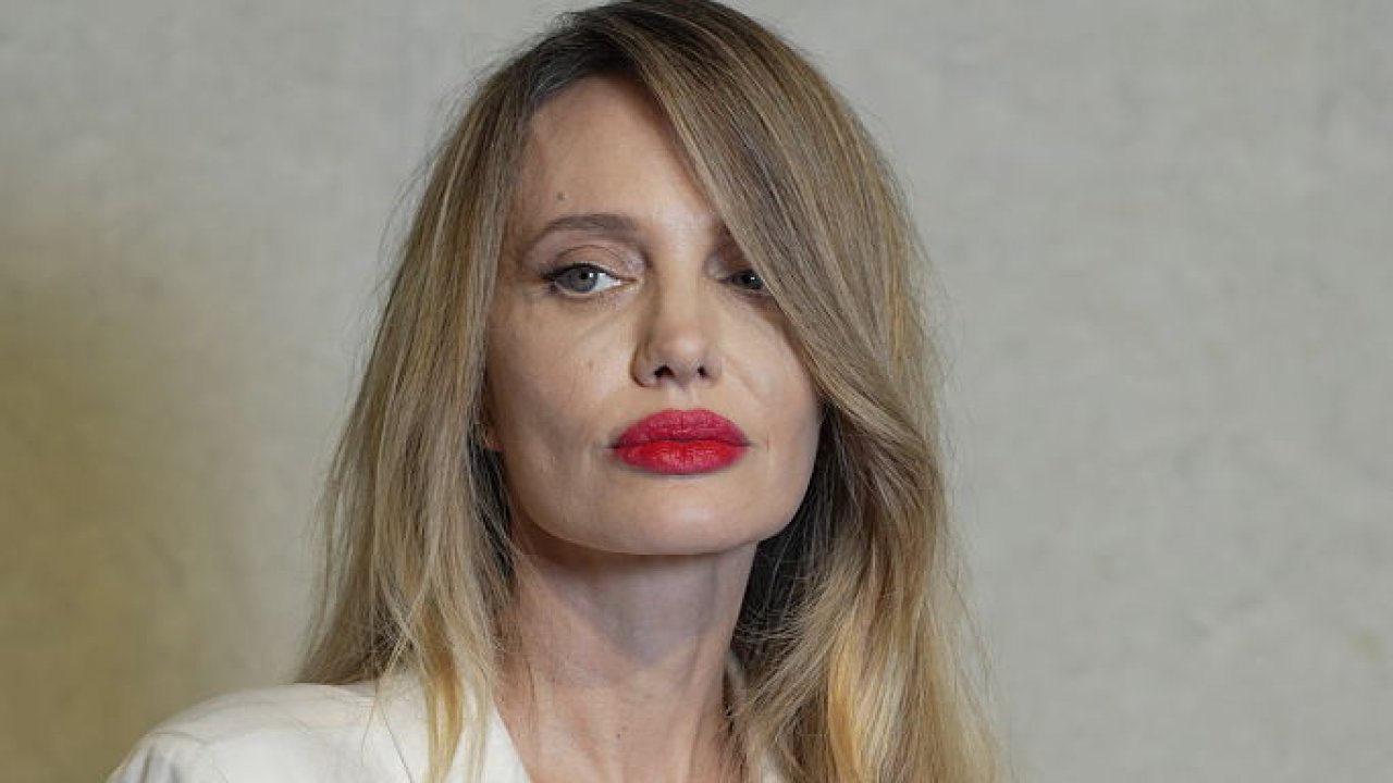 Анджелина Джоли появилась на публике с яркими красными губами, белым халатом и взлохмаченными светлыми волосами.